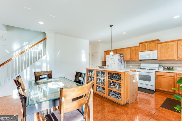 kitchen with pendant lighting, light tile patterned floors, white appliances, and backsplash