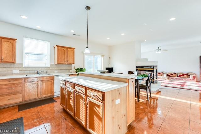 kitchen featuring dishwasher, light tile patterned floors, tasteful backsplash, sink, and pendant lighting