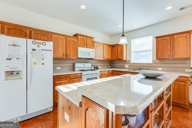 kitchen featuring hanging light fixtures, white appliances, backsplash, and a center island