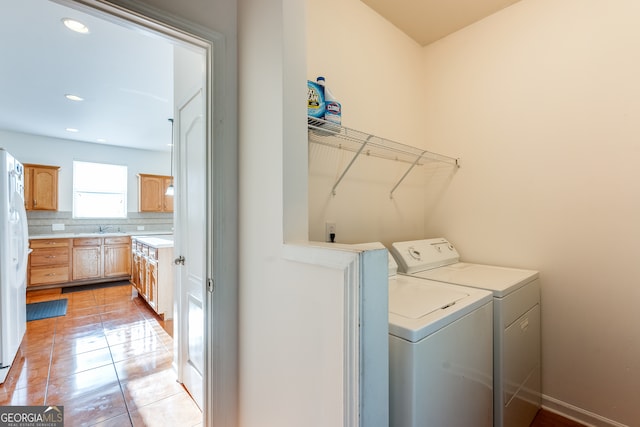 washroom with separate washer and dryer, light tile patterned floors, and sink