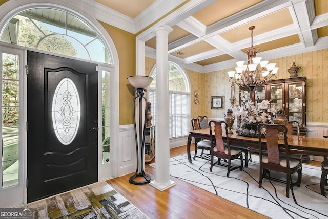 foyer with coffered ceiling, ornate columns, light hardwood / wood-style flooring, and a notable chandelier