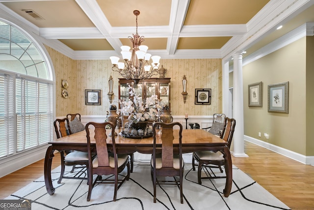 dining room with decorative columns, coffered ceiling, an inviting chandelier, and light hardwood / wood-style floors