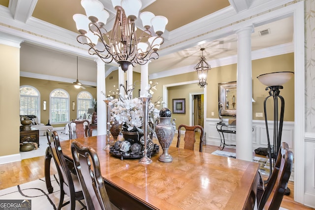 dining room with ceiling fan with notable chandelier, ornate columns, light wood-type flooring, and crown molding