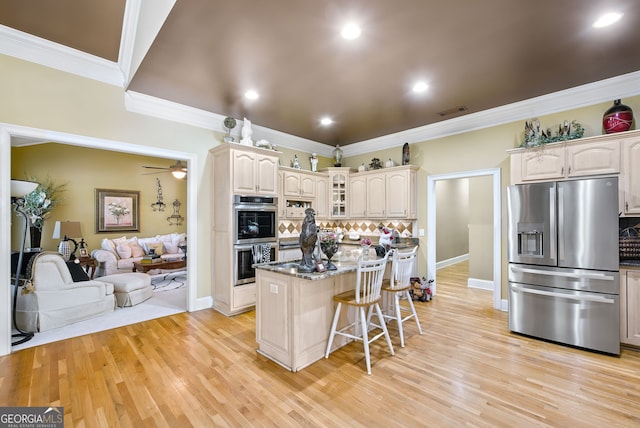 kitchen with ornamental molding, light hardwood / wood-style flooring, appliances with stainless steel finishes, and tasteful backsplash