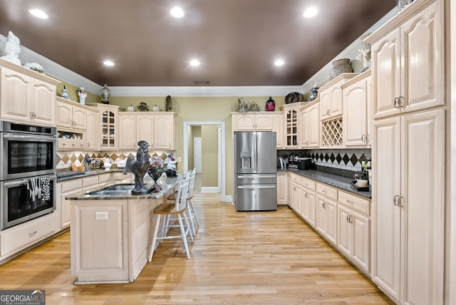 kitchen featuring stainless steel appliances, light hardwood / wood-style floors, a kitchen island, and backsplash