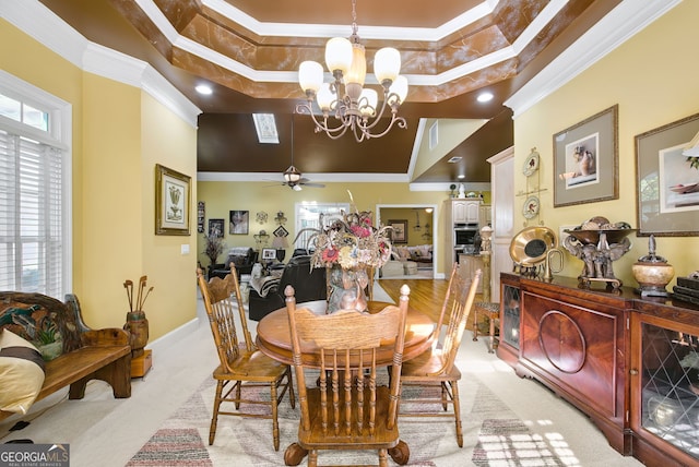 dining area with a high ceiling, ceiling fan with notable chandelier, a raised ceiling, and crown molding