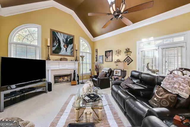 carpeted living room with a wealth of natural light, vaulted ceiling, ceiling fan, and crown molding