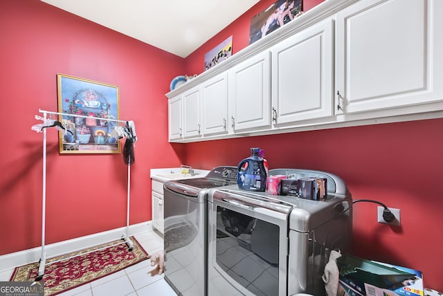 washroom featuring cabinets, light tile patterned floors, and washer and clothes dryer