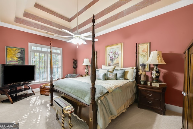 carpeted bedroom featuring ceiling fan, a raised ceiling, and crown molding