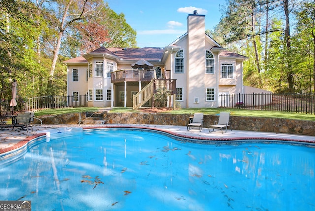 view of swimming pool featuring a wooden deck and a patio