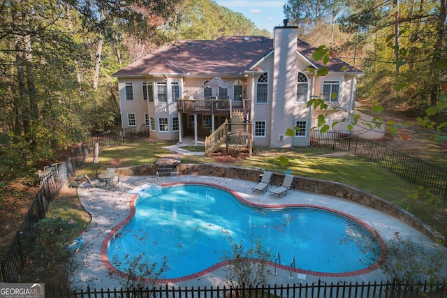 view of swimming pool featuring a patio, a yard, and a deck