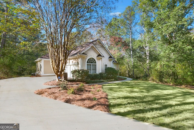 view of front of property with a garage and a front lawn