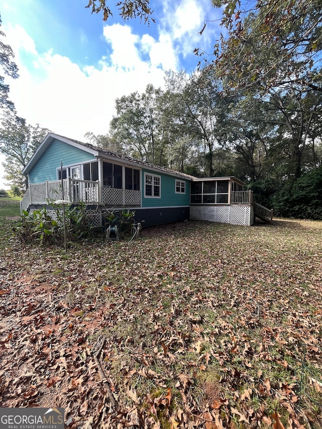 back of property featuring a sunroom and a deck