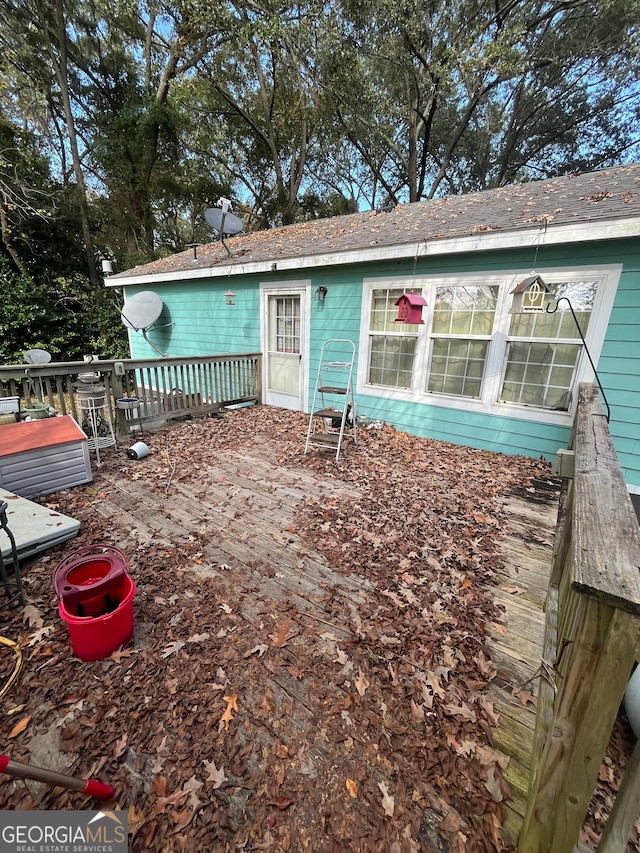 rear view of house featuring a wooden deck