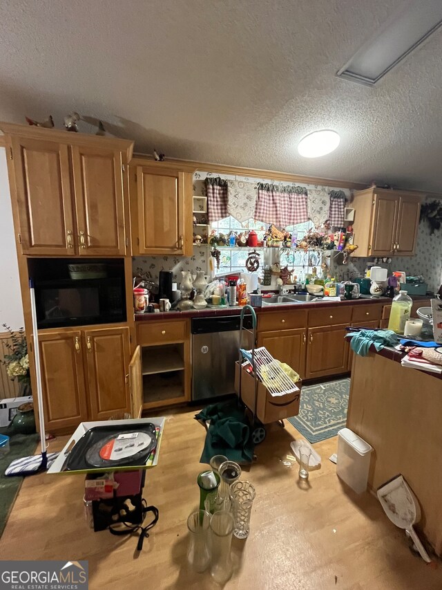 kitchen with dishwasher, sink, and a textured ceiling