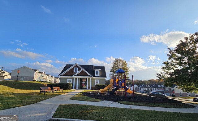 view of front of home with a front yard and a playground