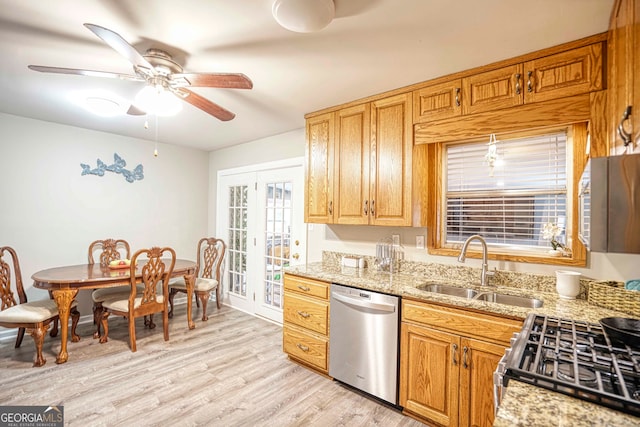 kitchen with stainless steel appliances, light hardwood / wood-style floors, sink, light stone countertops, and ceiling fan