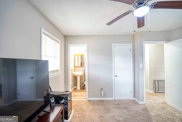 carpeted office space featuring sink and ceiling fan