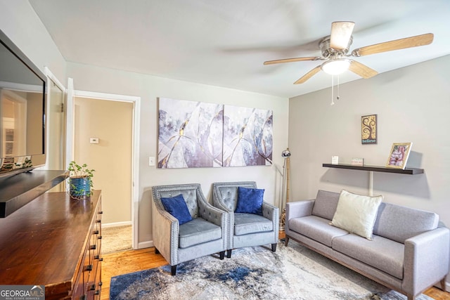 living room with light wood-type flooring and ceiling fan