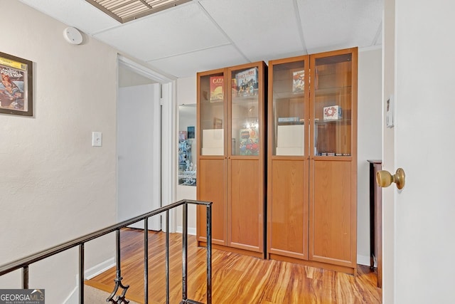 hallway featuring a paneled ceiling and light hardwood / wood-style flooring