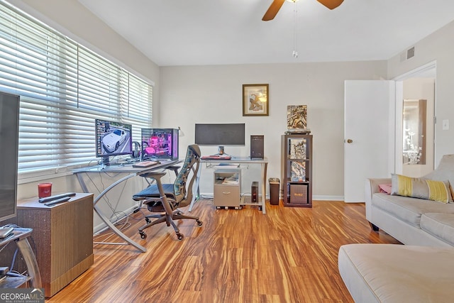 home office featuring ceiling fan and light hardwood / wood-style flooring