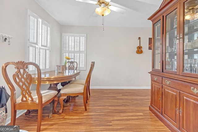 dining area with light wood-type flooring and ceiling fan