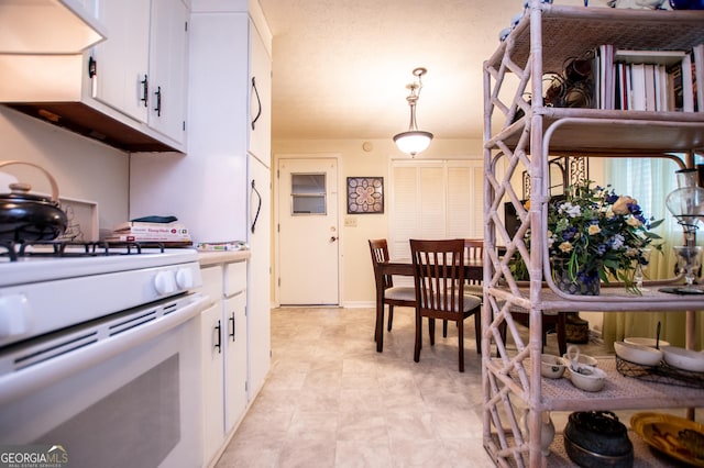 kitchen with white cabinets, hanging light fixtures, and gas range gas stove