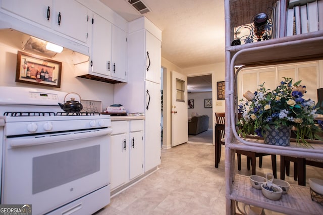 kitchen with white gas range and white cabinets