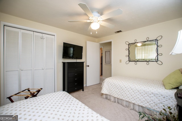 carpeted bedroom featuring ceiling fan and a closet