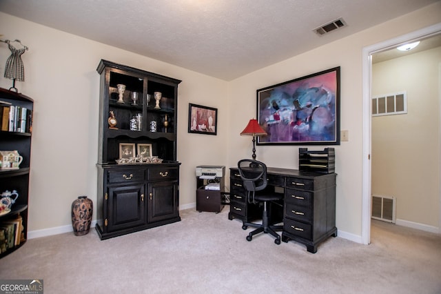 carpeted office space featuring a textured ceiling