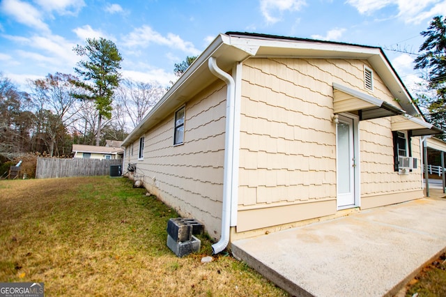 view of side of property featuring a lawn, central AC, and cooling unit