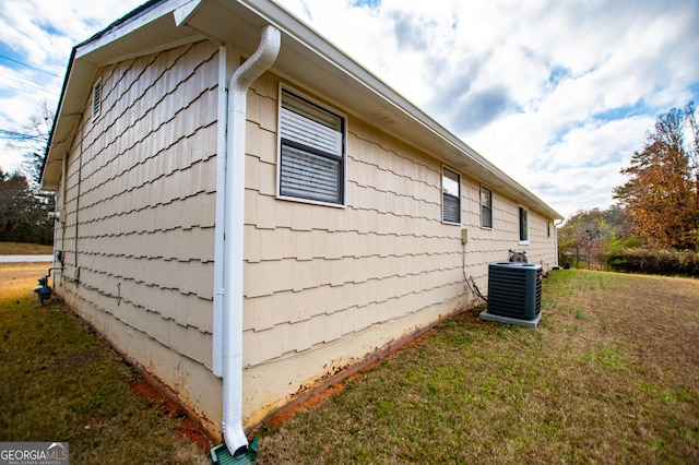 view of home's exterior featuring central AC unit and a yard