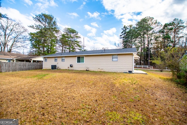 rear view of house featuring a yard and cooling unit