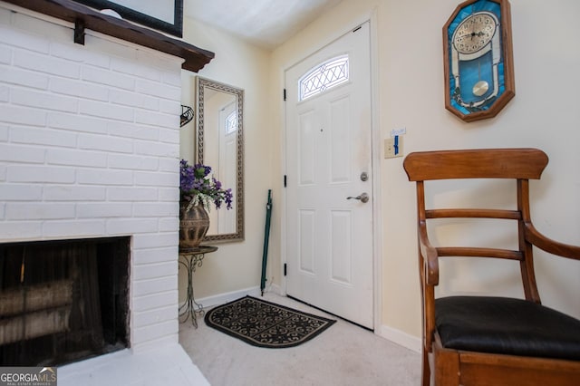 foyer entrance with a fireplace and light carpet