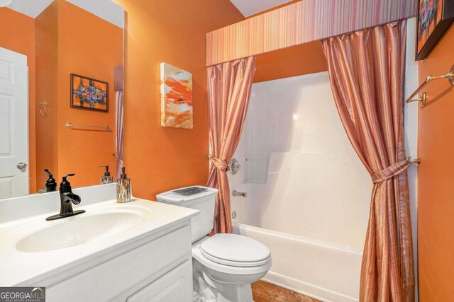 full bathroom with vanity, shower / bath combo with shower curtain, and toilet