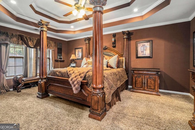 bedroom featuring ornamental molding, light colored carpet, ceiling fan, and a tray ceiling