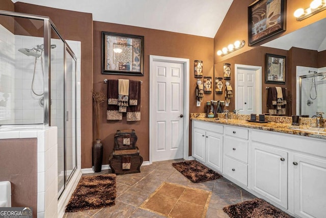 bathroom with walk in shower, vanity, and lofted ceiling