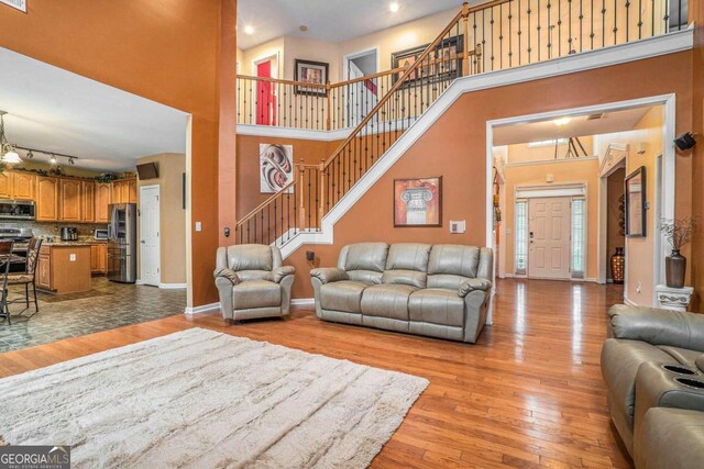 living room with a high ceiling and light hardwood / wood-style flooring