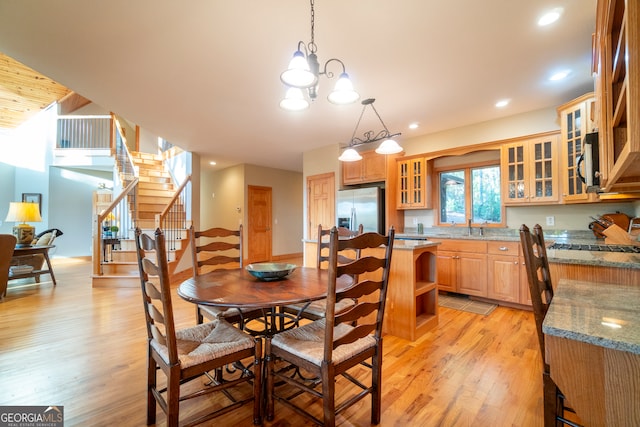 dining space with a notable chandelier and light wood-type flooring