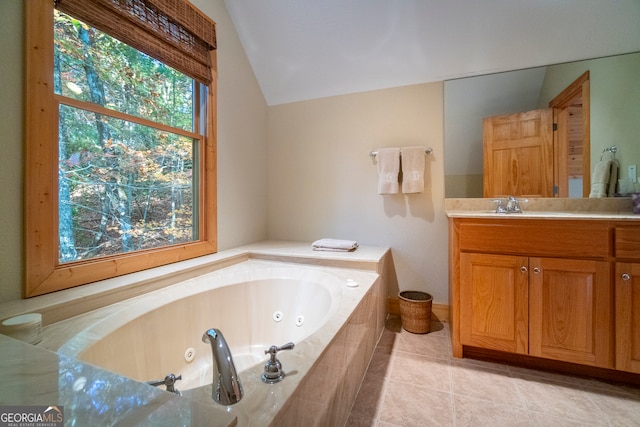 bathroom with tile patterned flooring, vanity, tiled bath, and vaulted ceiling