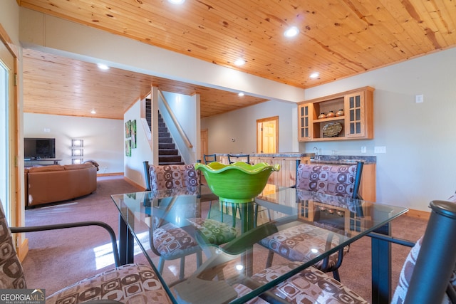 carpeted dining space featuring wooden ceiling, lofted ceiling, and wet bar