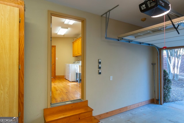 garage with washer and dryer and a garage door opener