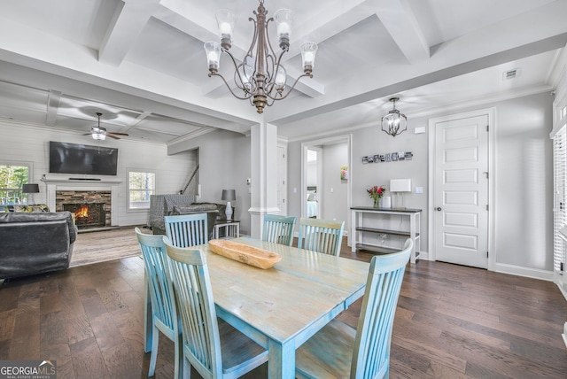 dining area featuring beam ceiling, a stone fireplace, crown molding, coffered ceiling, and dark wood-type flooring