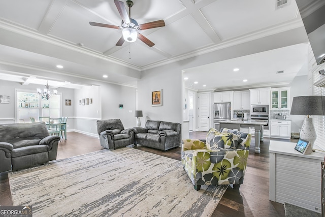 living room featuring ornamental molding, dark hardwood / wood-style flooring, coffered ceiling, sink, and ceiling fan with notable chandelier