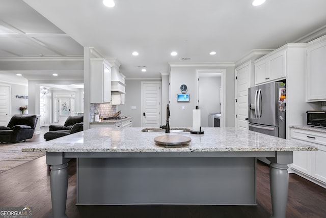 kitchen with a kitchen breakfast bar, a large island with sink, sink, and stainless steel fridge with ice dispenser