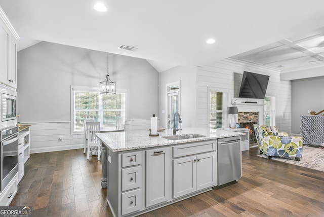 kitchen with dark hardwood / wood-style flooring, sink, pendant lighting, a fireplace, and appliances with stainless steel finishes