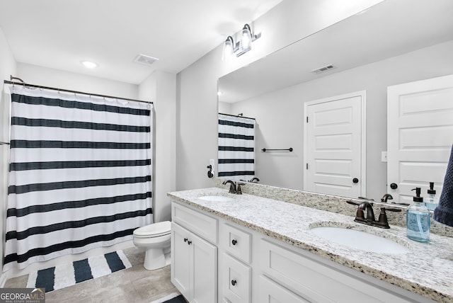 bathroom with curtained shower, vanity, and toilet