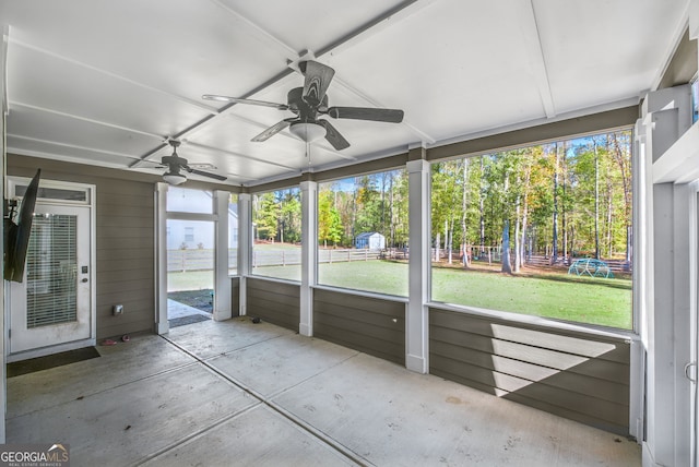 unfurnished sunroom featuring ceiling fan