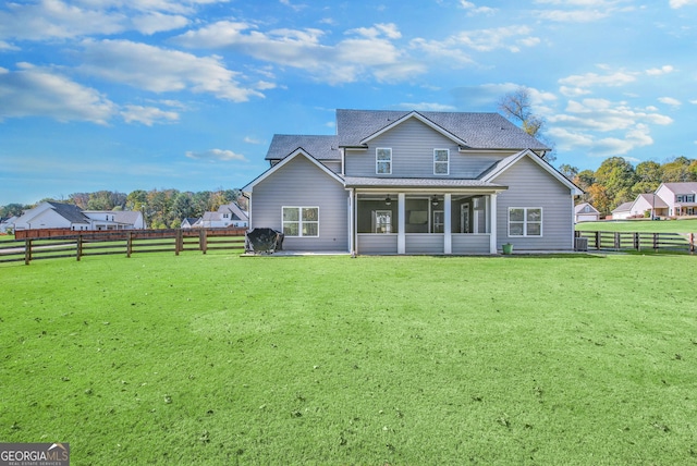 rear view of house with a sunroom and a yard