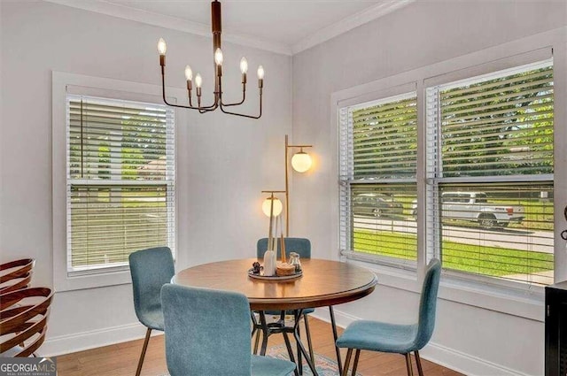 dining space featuring a notable chandelier, hardwood / wood-style flooring, and crown molding